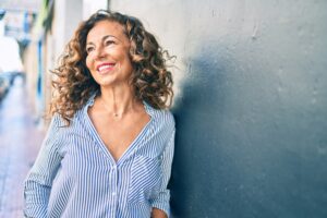 Smiling woman leaning on wall